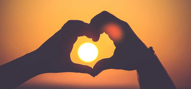 Two hands make the shape of a heart.